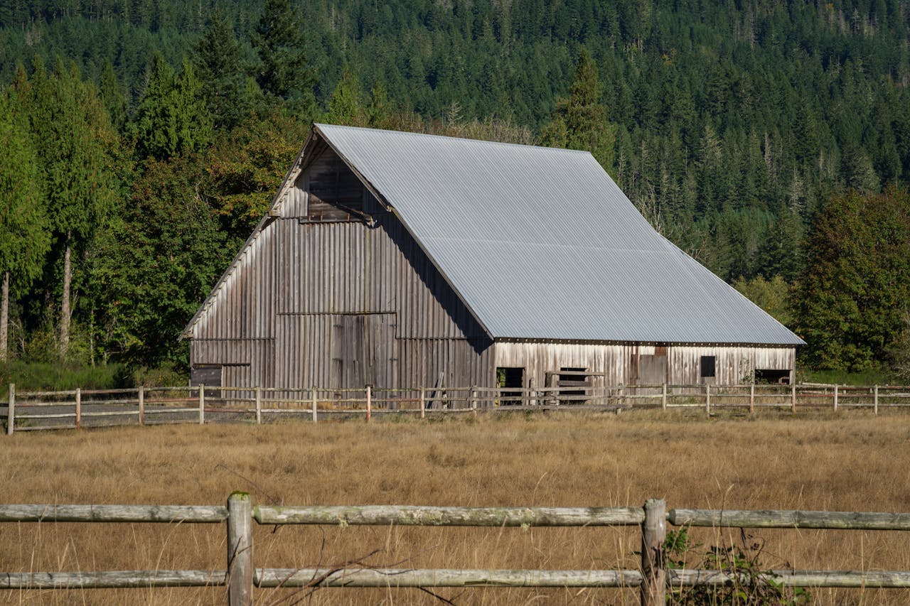 A rustic barn surrounded by trees and grass in rural Washington state.